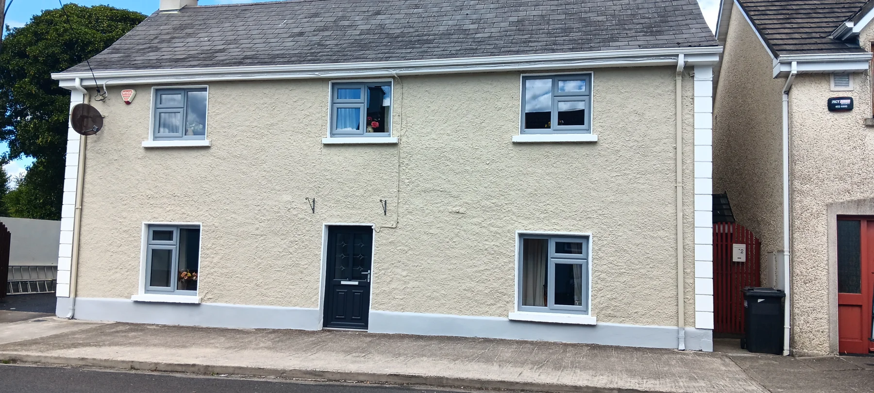 Freshly painted cream house with charcoal base and door